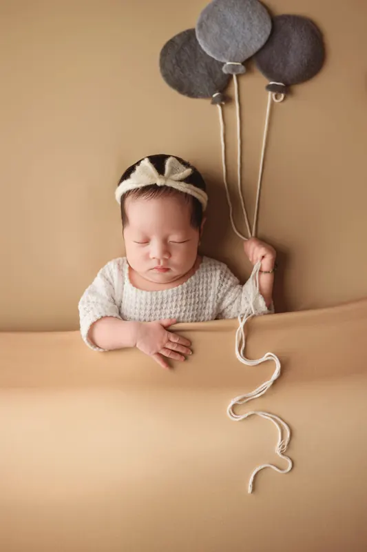 Baby mit Haarband und Luftballons, Studiofoto