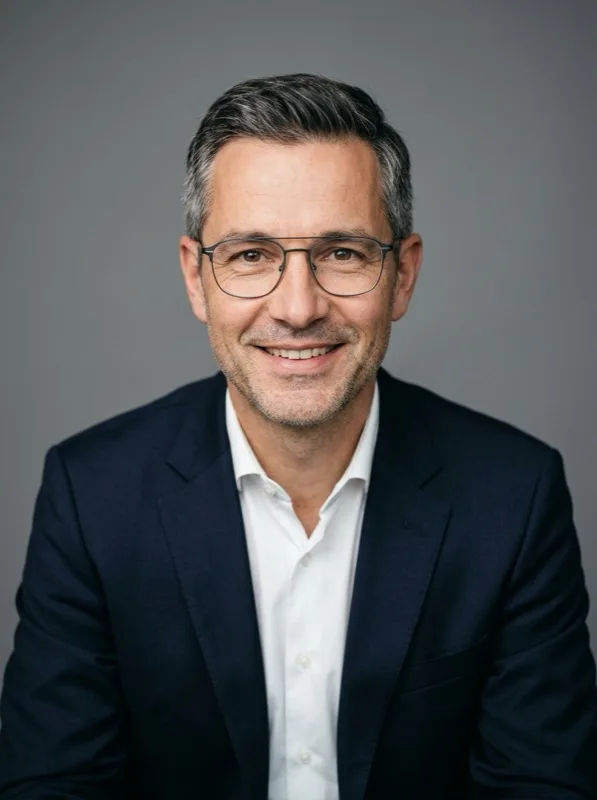 Mann mit Brille im Anzug, freundliches Bewerbungsfoto