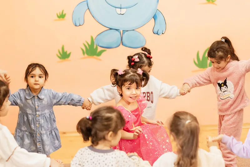 Kinder im Kreis in einem bunten Klassenzimmer