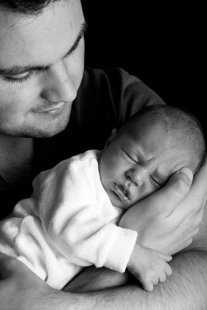 Ein Mann hält ein Baby im Arm