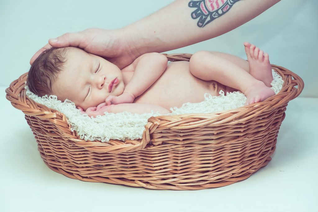 Babyfotoshooting mit Baby in einem kleinen Korb mit Decke